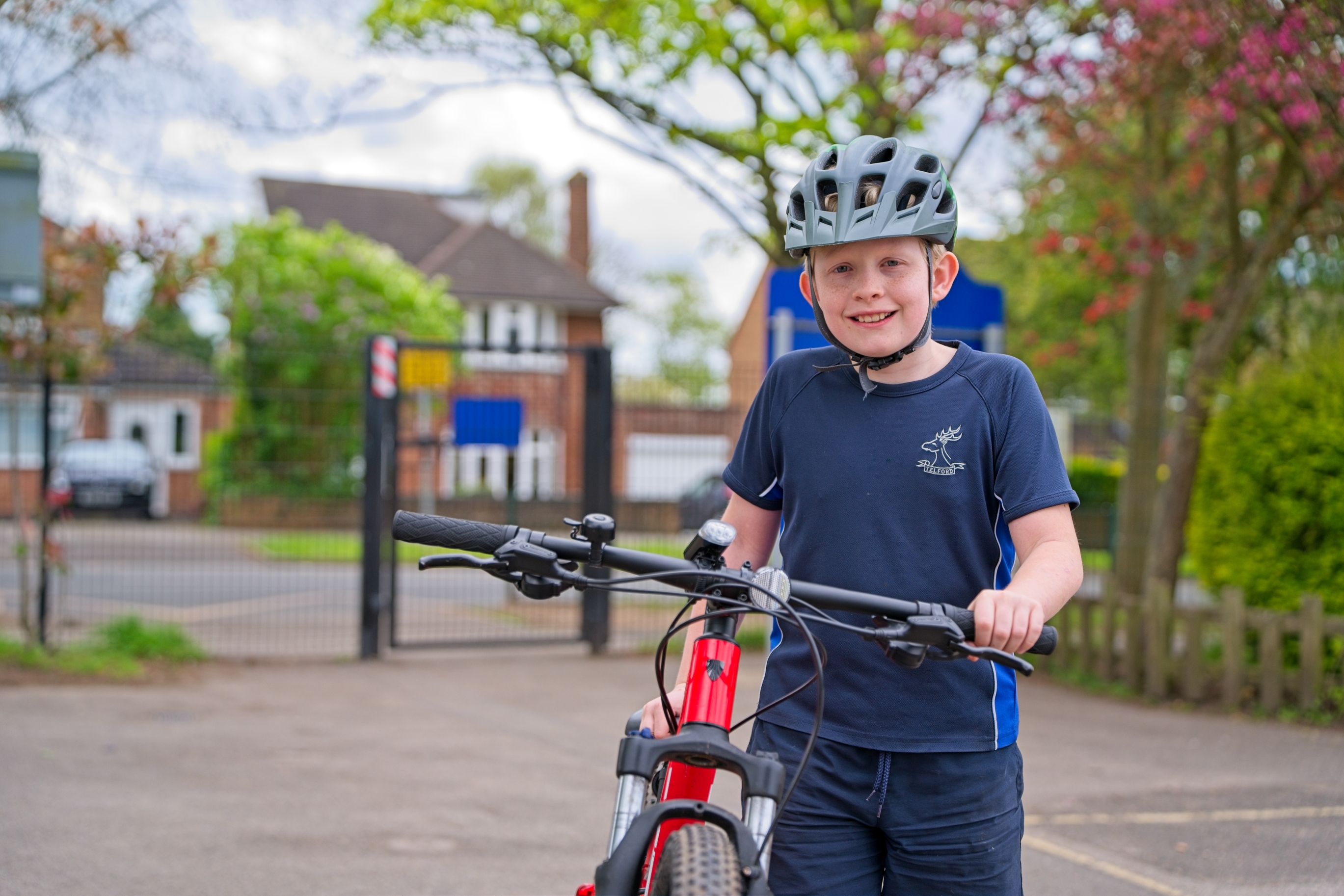 Pupil arriving in school with his bike and cycling helmet.