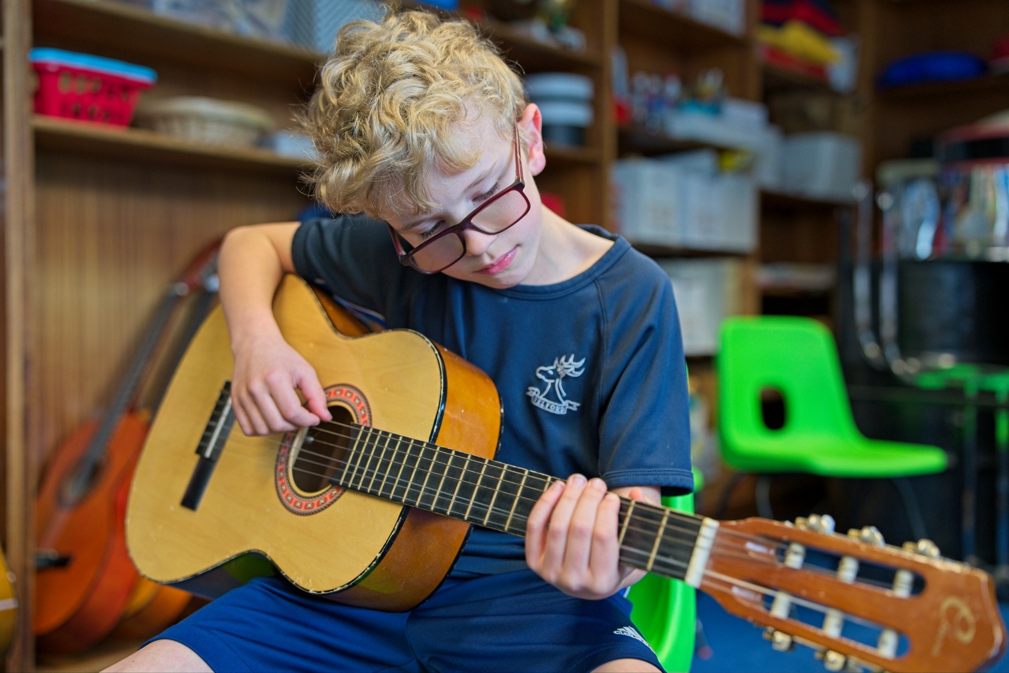 Pupil playing the guitar in the Music Room.